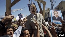 Demonstran anti pemerintah menggantung patung Presiden Yaman Ali Abdullah Saleh dalam unjuk rasa di Sanaa (15/10).