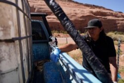 FILE - Chris Topher Chee waits for water to fill a tank in his truck in Oljato-Monument Valley, Utah, on the Navajo reservation, April 27, 2020. People living in rural or tribal communities are among the toughest to count in the U.S. census.