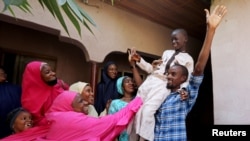 FILE - Muhammed Bello, a rescued student, is carried by his father as his relatives celebrate after he retuned home in Kankara, Nigeria, Dec. 19, 2020. 