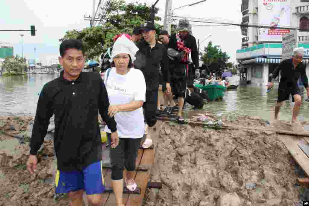 A couple evacuates their flooded neighborhood, Ayutthaya, Thailand, October 6, 2011. (VOA - D. Schearf)