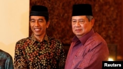 FILE - Indonesian President Susilo Bambang Yudhoyono (r) shakes hand with presidential candidate Joko "Jokowi" Widodo during a meeting at the presidential palace in Jakarta. 
