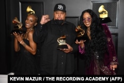 In this handout photo courtesy of The Recording Academy, (L-R) Tiara Thomas, Jeff Robinson, and H.E.R., winners of Song of the Year for "I Can't Breathe", poses in the media room during the 63rd Annual GRAMMY Awards in Los Angeles, California, March 14, 2021.