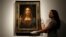 FILE - Members of Christie's staff pose for pictures next to Leonardo da Vinci's "Salvator Mundi" painting which will be auctioned by Christie's in New York in November, in London, Britain, Oct. 24, 2017. 