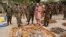 Military officials stand near ammunitions seized from suspected members of Hezbollah after a raid of a building in Kano, Nigeria, May 30, 2013.
