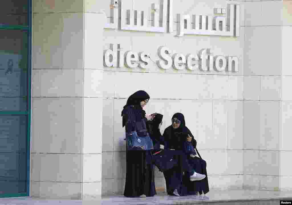 Women rest after casting their votes at a polling station.