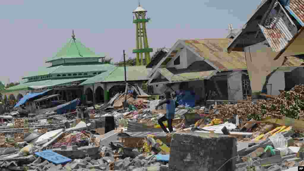 مرد نجات یافته از زلزله و سونامی در میان خانه های ویران شده در اندونزیا&nbsp;