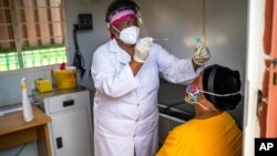 Asnath Masango, gives a patient a COVID-19 test at the Ndlovu clinic in Elandsdoorn, 200 kms north-east of Johannesburg Thursday Feb. 11, 2021. The center is running a study of the Johnson & Johnson COVID-19 vaccine.