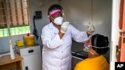 Asnath Masango, gives a patient a COVID-19 test at the Ndlovu clinic in Elandsdoorn, 200 kms north-east of Johannesburg Thursday Feb. 11, 2021. The center is running a study of the Johnson & Johnson COVID-19 vaccine.