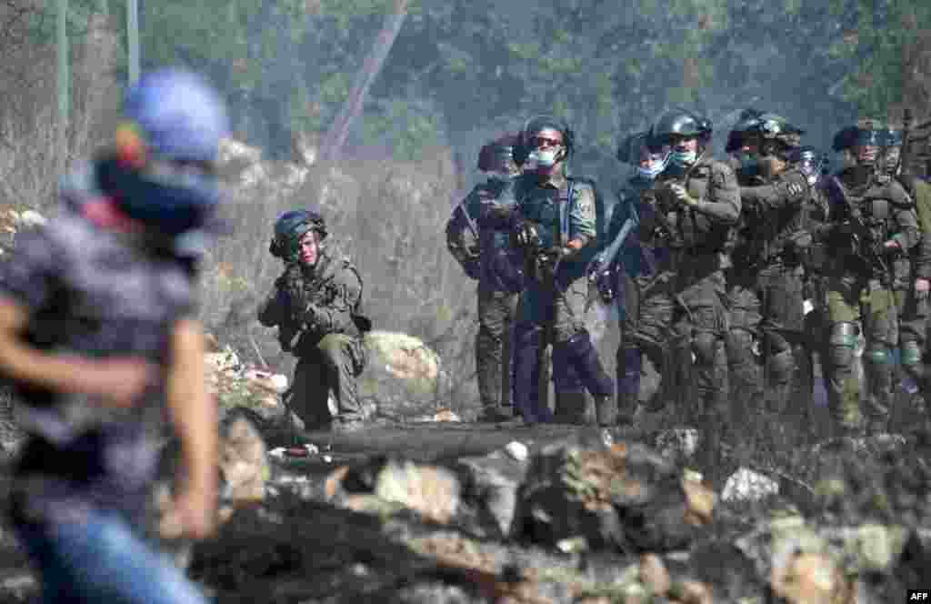 Israeli security forces take position during clashes with Palestinian protesters at a weekly demonstration in the village of Kfar Qaddum in the occupied West Bank.