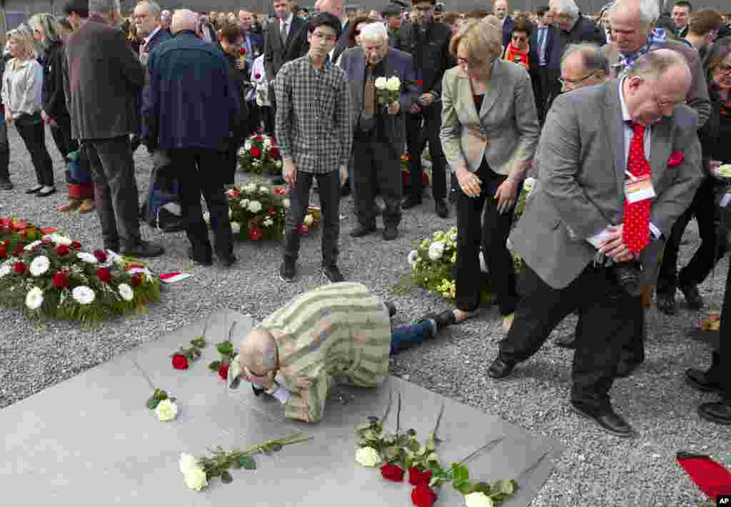 Nazi concentration camp survivor Alexander Bytschok of Kyiv, Ukraine, mourns on a plain metal plaque during the commemoration ceremonies for the 73th anniversary of the liberation of the former Nazi concentration camp Buchenwald near Weimar, Germany.