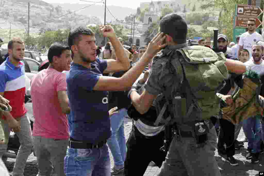 Polisi perbatasan Israel berkelahi dengan seorang pria Palestina dalam konfrontasi setelah shalat Jumat di luar Kota Tua di Yerusalem (2/10). (AP/Mahmoud Illean)