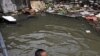 A Cambodia man, left, gets out from his home with floodwaters surrounding it in a slum in Phnom Penh, Cambodia, Tuesday, Oct. 4, 2011. Flash floods, the worst to hit Cambodia since 2000, have killed at least 150 people in this Southeast Asian nation since