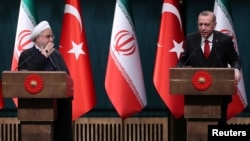 FILE - Turkish President Recep Tayyip Erdogan and his Iranian counterpart, Hassan Rouhani, hold a joint news conference after their meeting in Ankara, Dec. 20, 2018.