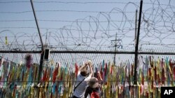 Visitors hang a ribbon on a wire fence decorated with other ribbons at the Imjingak Pavilion in Paju, South Korea, Tuesday, June 9, 2020. North Korea said Tuesday it will cut off all communication channels with South Korea as it escalates its…