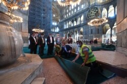 The head of Turkey's Religious Affairs Directorate, Ali Erbas, visits Hagia Sophia as workers lay carpets in its interior, in Istanbul, Turkey, July 22, 2020.
