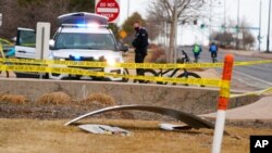 A piece of debris from a commercial airplane is marked off by police tape where it landed along Midway Boulevard in Broomfield, Colo., as the plane shed parts while making an emergency landing at nearby Denver International Airport, Feb. 20, 2021.