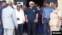 FILE - Prime Minister Huber Minnis, center, and opposition leader Philip Davis, left, prepare to board a US Coast Guard plane to survey damage caused by Hurricane Dorian in Nassau, Bahamas, Sept. 3, 2019. (John Marc Nutt/Reuters)