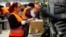 Employees handle packages in the new Amazon logistics center in Dortmund, Germany, Nov. 14, 2017.