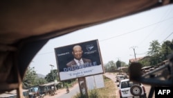 FILE - A convoy of the U.N. Multidimensional Integrated Stabilization Mission in the Central African Republic passes by an election poster of opposition candidate Anicet Georges Dologuélé, in Bangui, Dec. 25, 2020. 