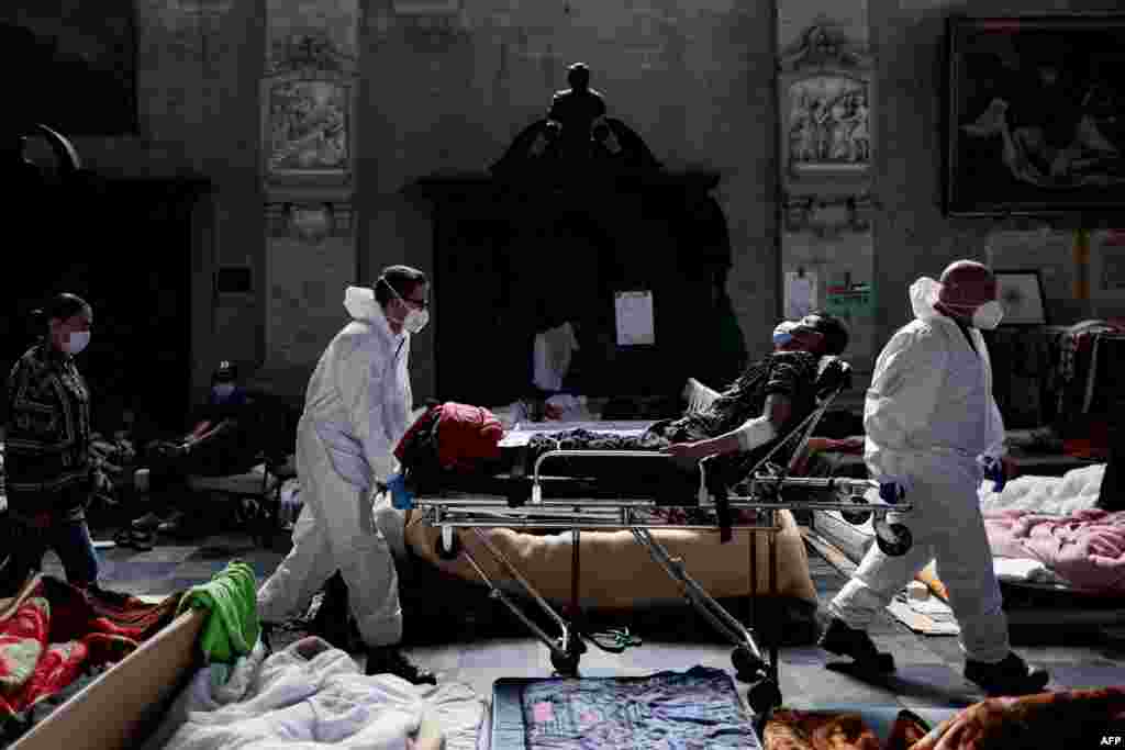 Nurses evacuate a migrant who is on a hunger strike to the hospital from Saint-Jean-Baptiste-au-Beguinage church in Brussels, Belgium.