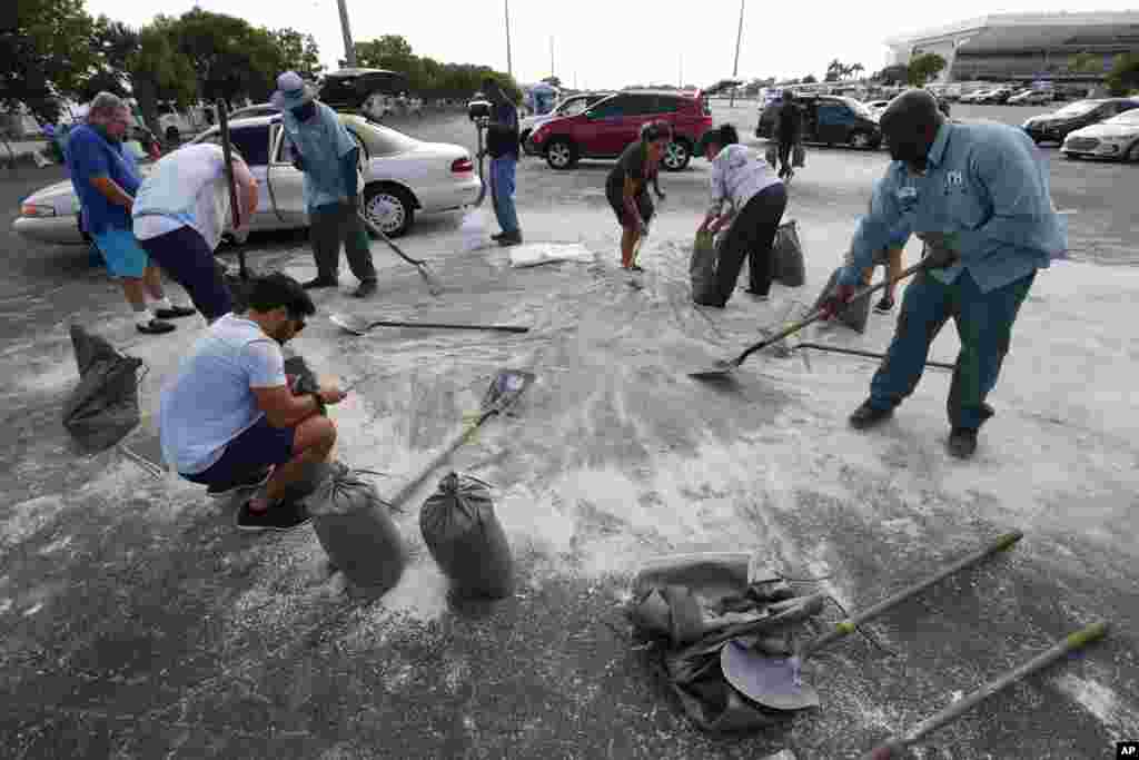 Residentes de Hallandale Beach, Florida, llenan sacos de arena en preparación para el huracán Dorian, el viernes 30 de agosto de 2019. La ciudad permitió que los residentes llenaran sacos de arena hasta que la arena se agotara. Toda Florida se encuentra en estado de emergencia y las autoridades instan a los residentes a que acumulen alimentos y suministros por una semana como consecuencia del huracán Dorian. (AP/Wilfredo Lee)