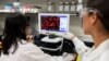 La Dre Sonia Macieiewski (R) et la Dre Nita Patel examinent un échantillon d'un virus respiratoire dans les laboratoires Novavax de Rockville, Maryland, l'un des laboratoires développant un vaccin pour le coronavirus.