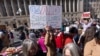 FILE - Barbara Singer of Bethesda, Md., who says she was let go from her USAID job in early February, shows her support of USAID, Feb. 28, 2025, in Washington. "It's a great agency that benefits all of us," she said, "Americans and people worldwide."