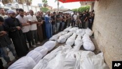 Mourners pray at the funeral for people killed in an Israeli strike, at Al-Aqsa Martyrs Hospital in Deir al-Balah, Gaza Strip, Aug. 17, 2024. The strike hit a house and adjacent warehouse sheltering displaced people at the entrance of the town of Zawaida, health officials said.