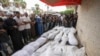 Mourners pray at the funeral for people killed in an Israeli strike, at Al-Aqsa Martyrs Hospital in Deir al-Balah, Gaza Strip, Aug. 17, 2024. The strike hit a house and adjacent warehouse sheltering displaced people at the entrance of the town of Zawaida, health officials said.