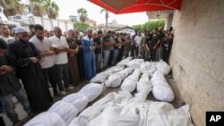 Mourners pray at the funeral for people killed in an Israeli strike, at Al-Aqsa Martyrs Hospital in Deir al-Balah, Gaza Strip, Aug. 17, 2024. The strike hit a house and adjacent warehouse sheltering displaced people at the entrance of the town of Zawaida, health officials said.