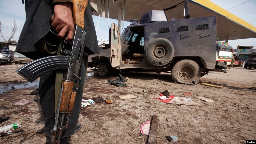 Seorang petugas keamanan berdiri di dekat kendaraan yang hancur akibat ledakan bom bunuh diri di dekat Peshawar (14/3). Sedikitnya tujuh orang dilaporkan tewas dan 35 lainnya terluka dalam serangan yang menarget panser militer ini.