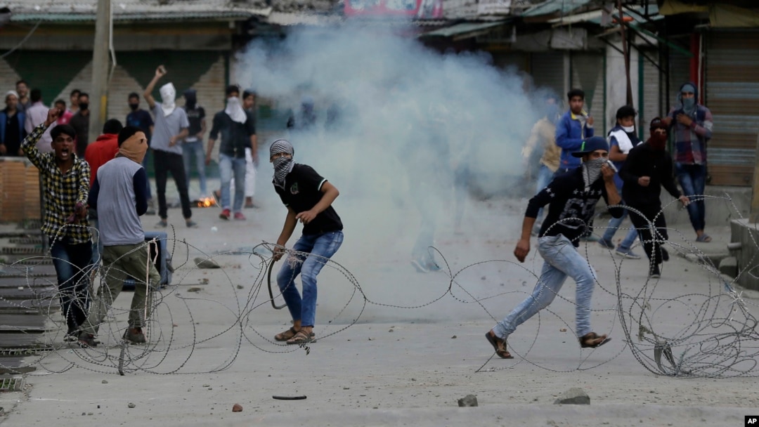 Pemrotes Kashmir meneriakkan slogan-slogan saat sebuah bom gas air mata meledak di dekat mereka di Srinagar, Kashmir yang dikuasai India, 12 Mei 2017. (AP Photo/Mukhtar Khan). 