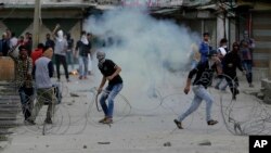 Pemrotes Kashmir meneriakkan slogan-slogan saat sebuah bom gas air mata meledak di dekat mereka di Srinagar, Kashmir yang dikuasai India, 12 Mei 2017. (AP Photo/Mukhtar Khan). 