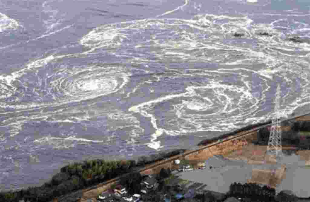 Swirls of waves approach to a coast in Iwaki, Fukushima Prefecture, northern Japan, March 11, 2011 after a powerful tsunami spawned by the largest earthquake in Japan's recorded history slammed the eastern coast