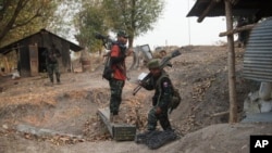 资料照片：克伦民族解放军和人民防卫军成员攻占了缅甸南部城镇妙瓦底城外一处缅甸陆军哨所后收集武器。(2024年3月11日)