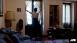 La trabajadora sexual mexicana Alenca, mira a través de una ventana antes de empezar su jornada de trabajo en su casa de Madrid en abril del 2020,en medio del confinamiento por la pandemia del coronavirus.