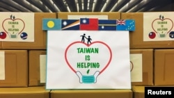 FILE - Tanda dengan bendera (dari kiri:) Tuvalu, Nauru, Taiwan, Kepulauan Marshall dan Palau sebelum upacara sumbangan masker kepada sekutu Taiwan di Pasifik, di kementerian luar negeri di Taipei, Taiwan 15 April 2020. (REUTERS/Ben Blanchard)