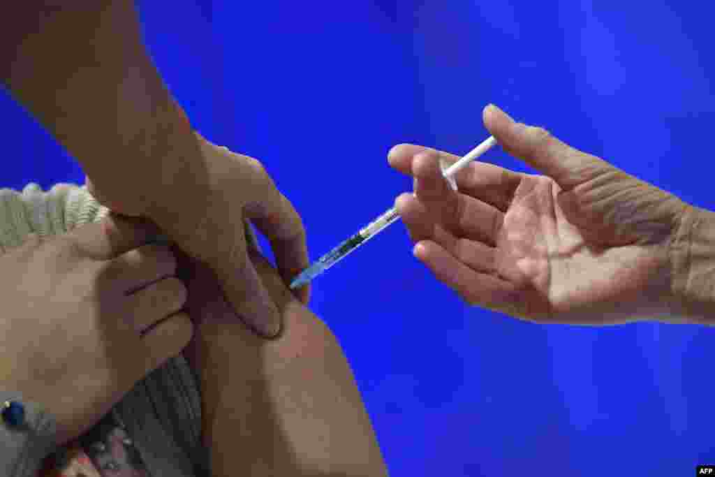 کارڈف، ساؤتھ ویلز کے ویکسینیشن مرکز میں ایک خاتون کو انجیکشن لگایا جا رہا ہے۔ برطانیہ بھر میں آٹھ دسمبر سے بڑے پیمانے پر ویکسینیشن مہم جاری ہے۔ 