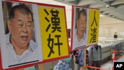Pro-China supporters hold the pictures of prominent Hong Kong democracy advocate and newspaper founder Jimmy Lai with Chinese words "Traitor of China" in Hong Kong, Feb. 18, 2021. 