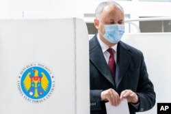 FILE - Incumbent Moldovan President Igor Dodon prepares to cast his vote in the country's presidential elections in Chisinau, Moldova, Nov. 1, 2020.