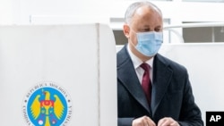 Incumbent Moldovan President Igor Dodon prepares to cast his vote in the country's presidential elections in Chisinau, Moldova, Nov. 1, 2020. 