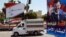 FILE - A vehicle drives past campaign posters for a presidential election in Damascus, Syria, May 12, 2014. Opposition politicians argue upcoming parliamentary elections are an effort by Assad to project a political legitimacy he doesn’t have.