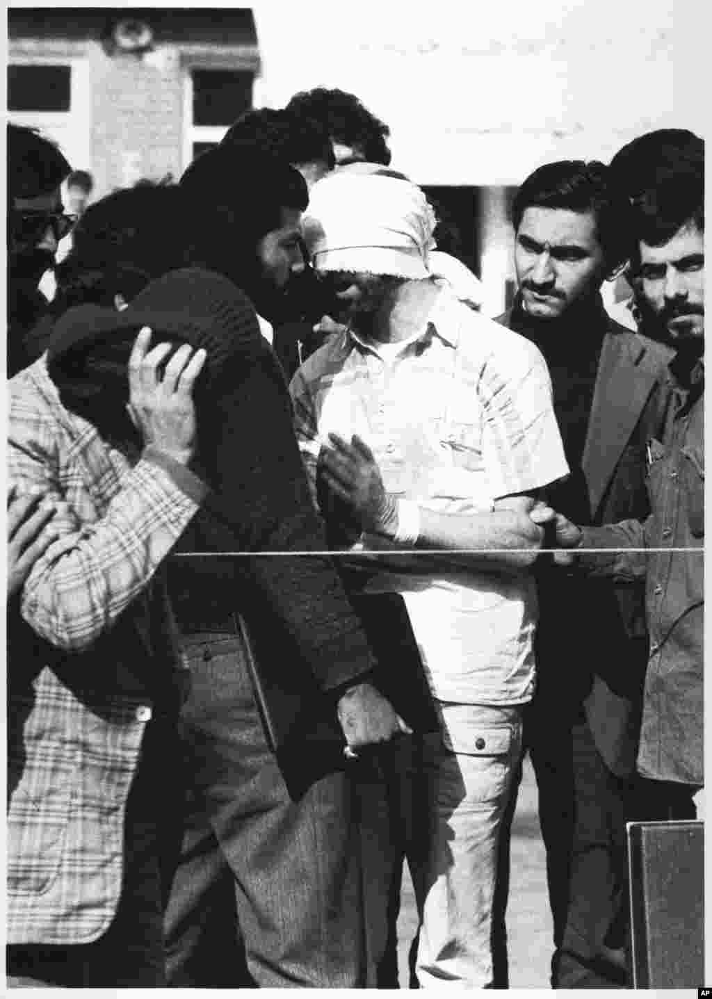 One of 60 U.S. hostages, blindfolded and with his hands bound, is being displayed to the crowd outside the U.S. Embassy in Tehran by Iranian hostage takers. The hostage crisis overshadowed all other events of the Carter presidency.