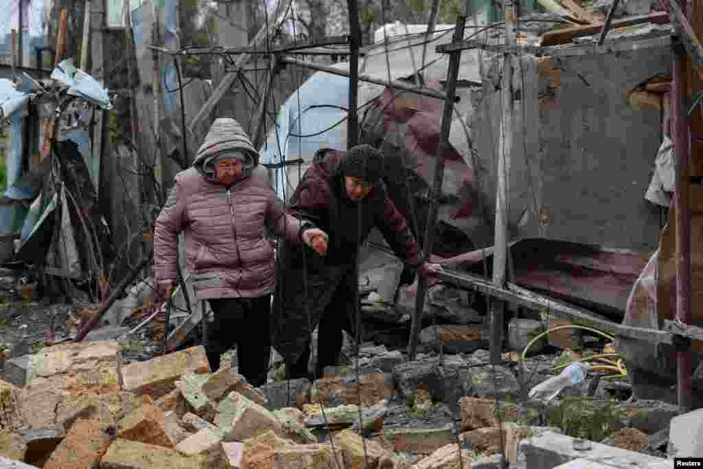 Residents walk through debris at a site of residential area damaged by a Russian drone strike in Odessa, Ukraine.