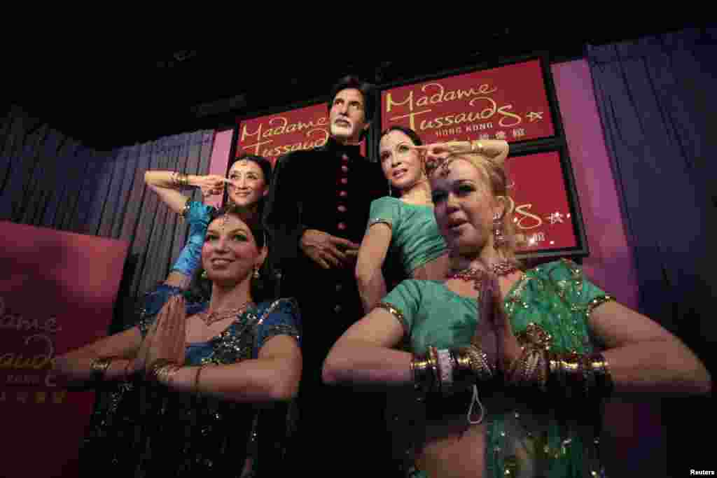 Para model berpose bersama patung lilin ikon industri Bollywood Amitabh Bachchan yang baru dipasang pada 24 Maret 2011 di Madame Tussauds, Hong Kong. Bachchan merupakan patung Bollywood pertama di museum tersebut. (Reuters/Tyrone Siu)