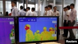 2015年6月9日在韩国位于首尔市中心，员工走过办公楼的热成像仪。