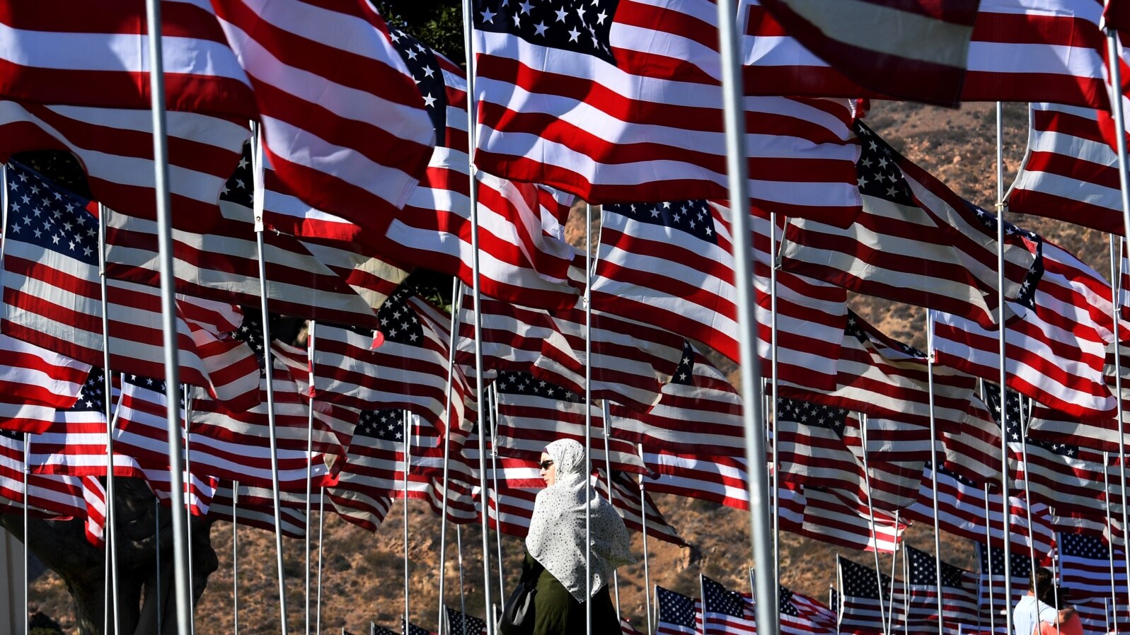 FILE - A young woman wearing a hijab stands amongst U.S. national flags erected by students and staff from Pepperdine University to honor the victims of the Sept. 11, 2001, attacks, at their campus in Malibu, California, Sept. 10, 2016.