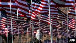 FILE - A young woman wearing a hijab stands amongst U.S. national flags erected by students and staff from Pepperdine University to honor the victims of the Sept. 11, 2001, attacks, at their campus in Malibu, California, Sept. 10, 2016.