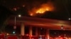 Fire trucks sit on Sepulveda Boulevard as fire burns along Interstate 405, Jan. 23, 2025, in Los Angeles. 