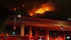 Fire trucks sit on Sepulveda Boulevard as fire burns along Interstate 405, Jan. 23, 2025, in Los Angeles. 